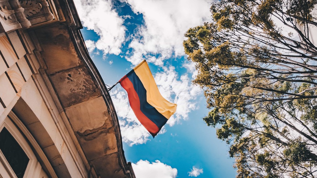 Eine Aufnahme der kolumbianischen Fahne wie sie in Bogota an einem Haus hängt. Das Foto ist bei der Kaffee Reise nach Kolumbien, beim Besuch der Bio Fairtrade Kaffee Bauern und der Betriebsbesichtigung der Bio Fairtrade Kaffee Kooperative entstanden. Wir besuchen auch Bogota.  